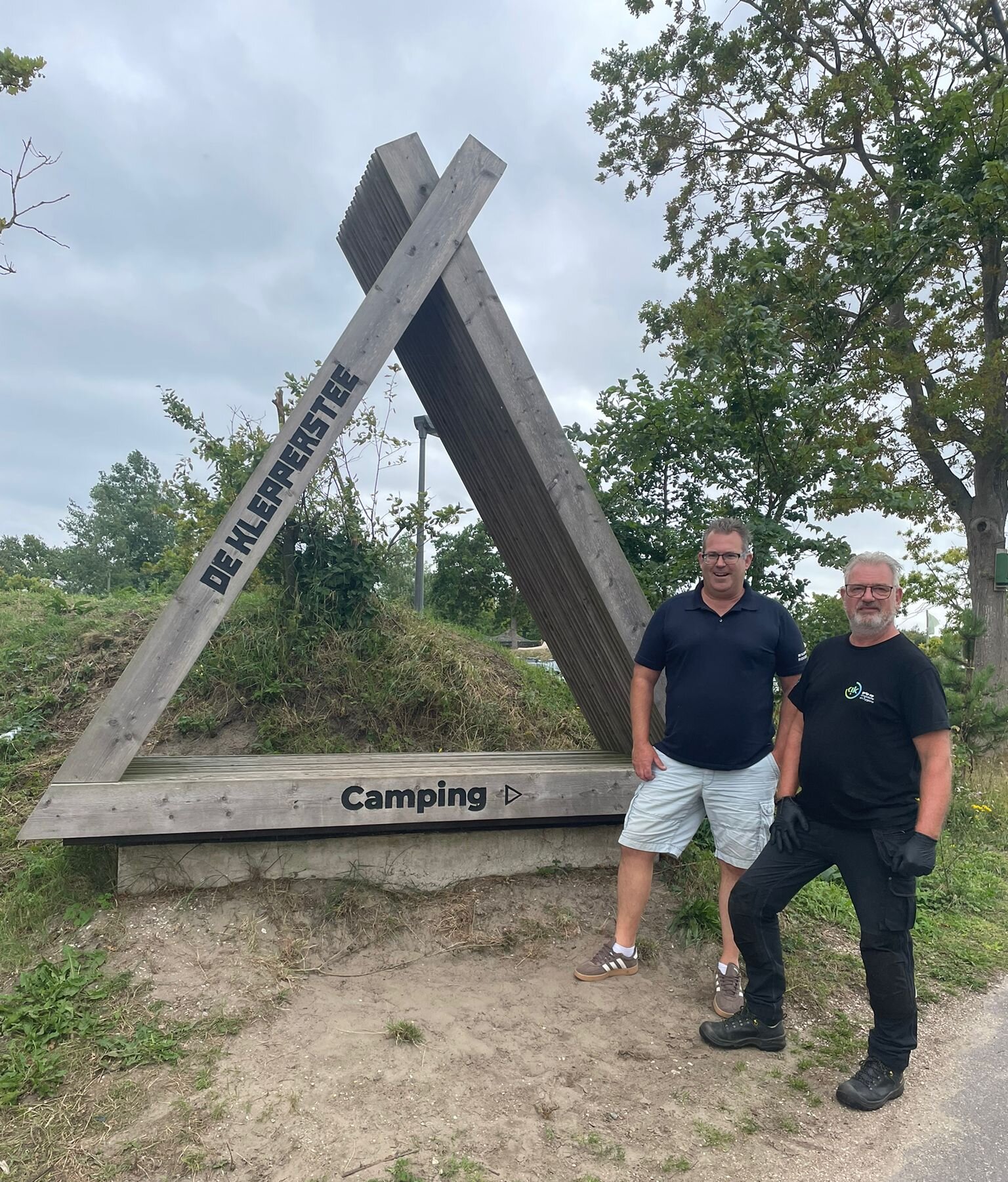 Parkmanager Wilbert Moerkerk staat samen met een technicus van Kik Ongediertebestrijding bij het entreebord van recreatiepark De Klepperstee in Ouddorp.